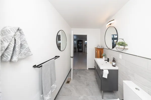 a bathroom with a sink a toilet and a mirror