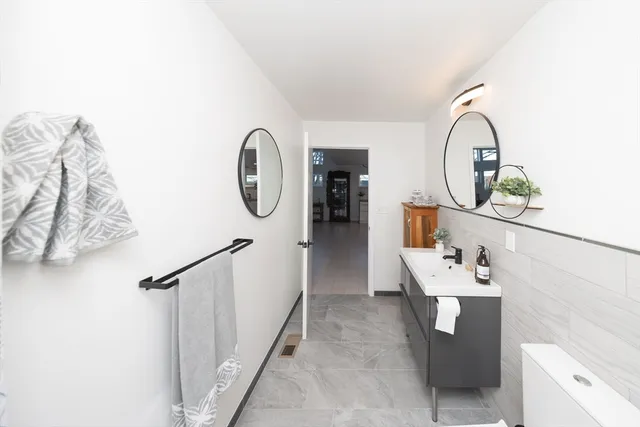 a bathroom with a sink a toilet and a mirror