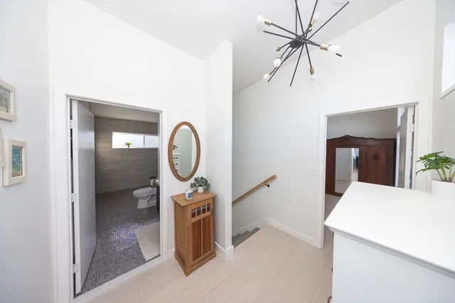 a room with a chandelier furniture and white walls