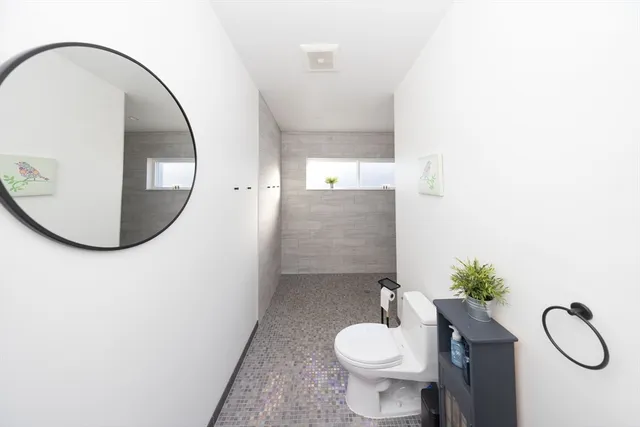 a living room with furniture gym equipment and large windows