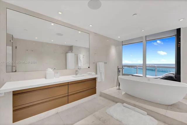 a bathroom with a tub sink shower and mirror