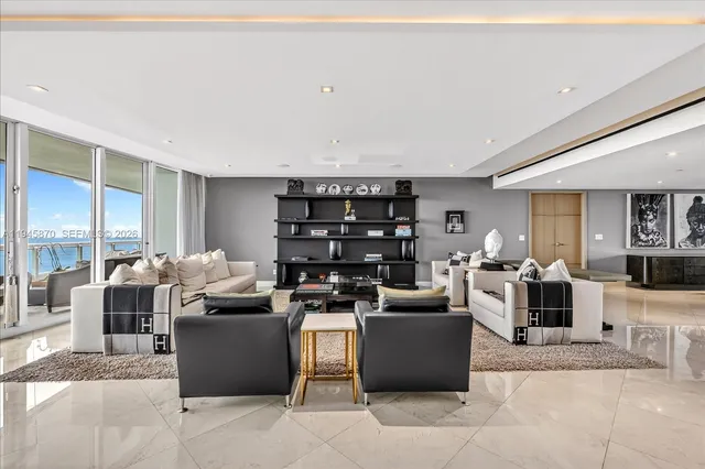 a living room with furniture a flat screen tv and a floor to ceiling window