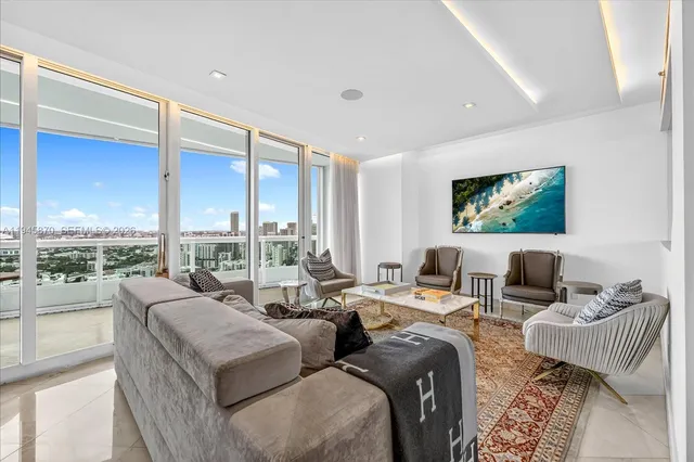 a living room with furniture and a floor to ceiling window