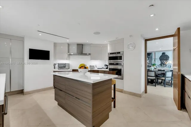 a kitchen with stainless steel appliances kitchen island granite countertop a stove a sink and a refrigerator