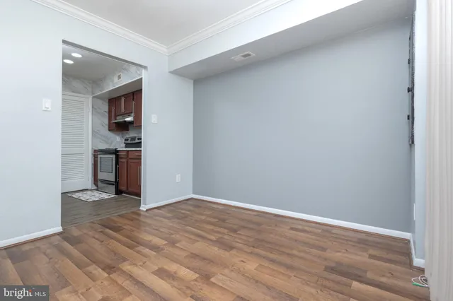 wooden floor in an empty room with kitchen