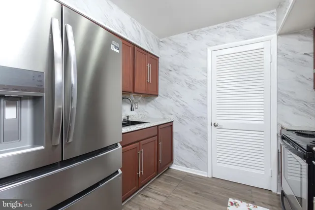 a kitchen with stainless steel appliances granite countertop a refrigerator and a sink