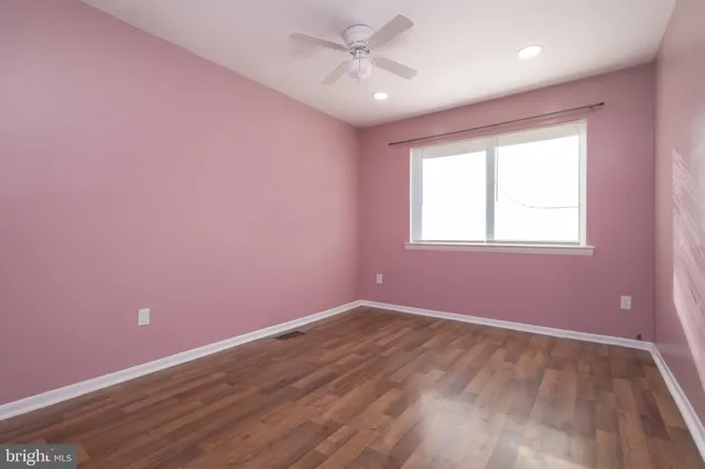 a view of a big room with wooden floor and windows