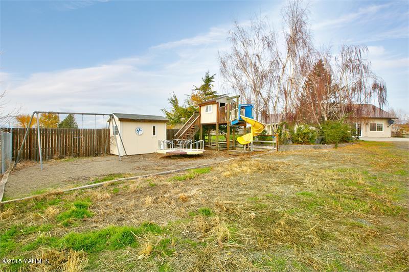 1350 Gilbert Road Zillah, WA 98953 - Photo 17 of 18 a view of a swimming pool with a bench and trees in the background