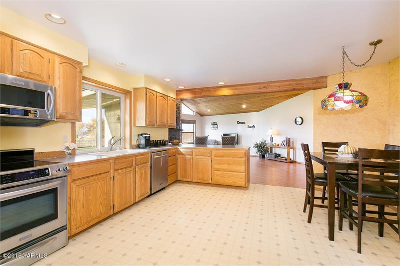 1350 Gilbert Road Zillah, WA 98953 - Photo 7 of 18 a kitchen with a table chairs microwave and cabinets