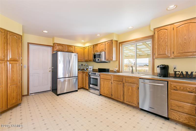 1350 Gilbert Road Zillah, WA 98953 - Photo 8 of 18 a kitchen with a refrigerator sink and cabinets