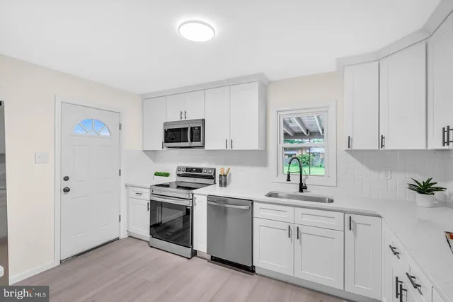 a kitchen with white cabinets stainless steel appliances and sink