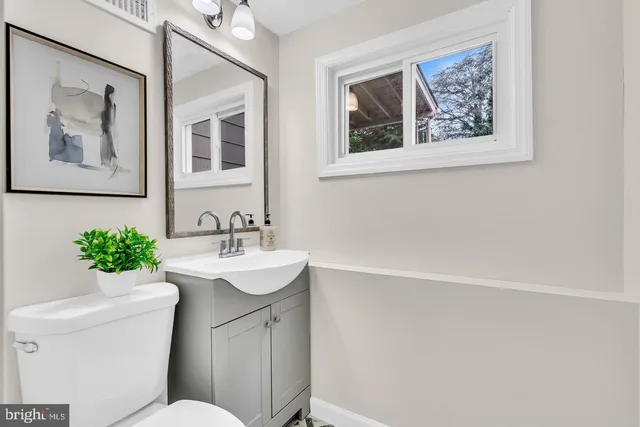 a bathroom with a sink mirror and toilet