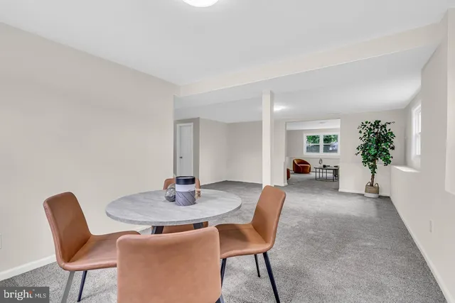 a dining room with furniture and potted plants