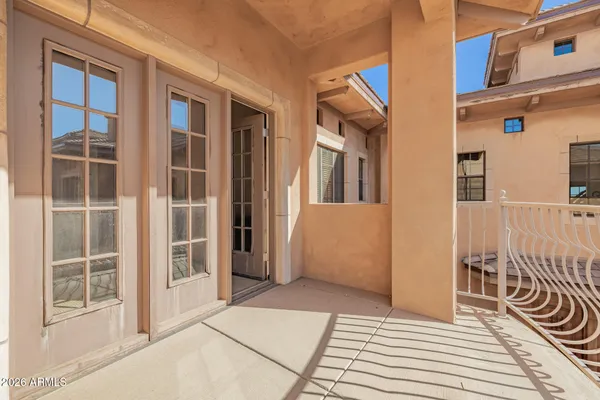 a view of a white house with large windows and a small yard