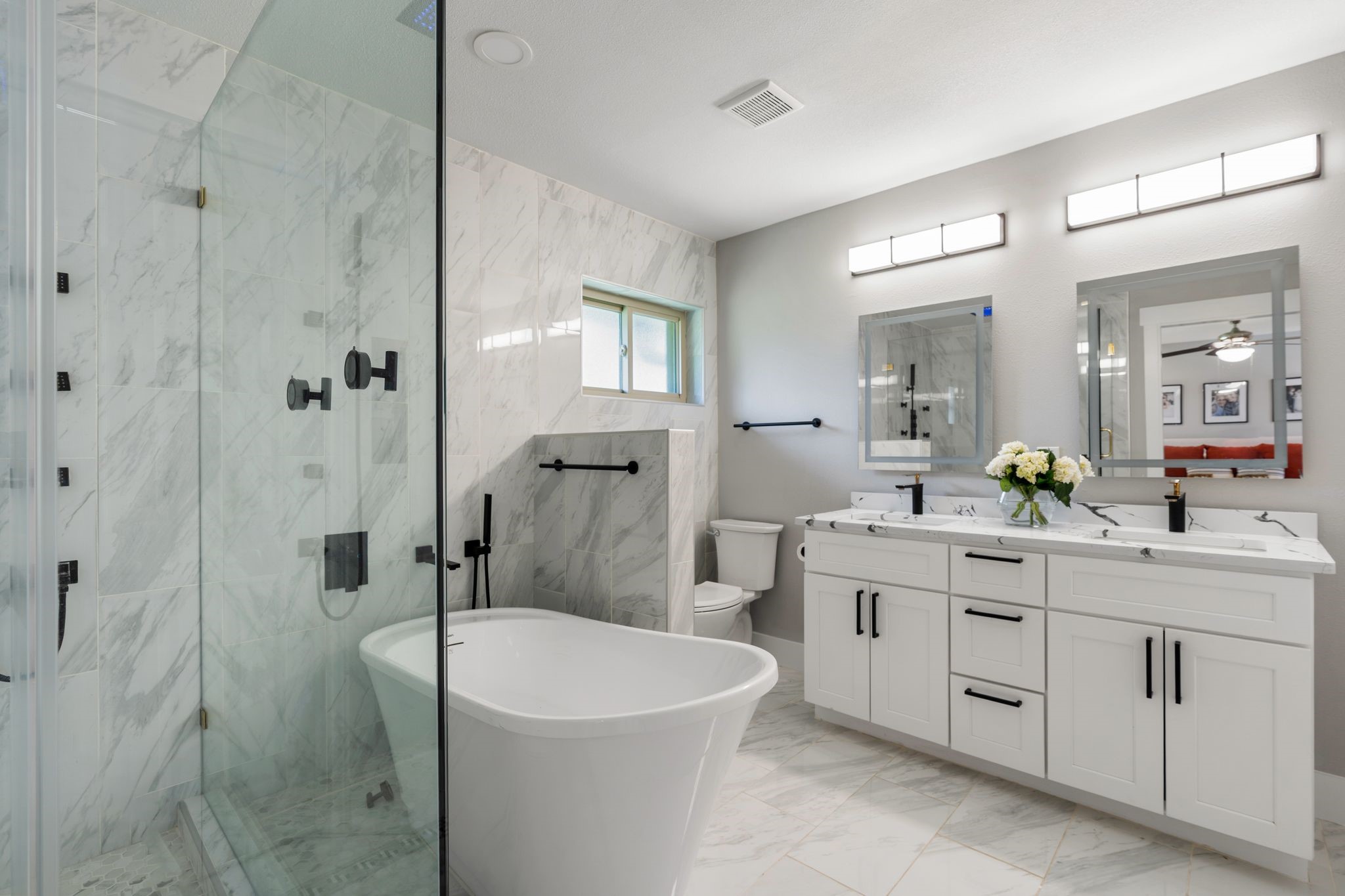 4423 Apollo Street Houston, TX 77018 - Photo 14 of 34 The luxurious primary ensuite features striking Greek key marble flooring, LED mirrors and abundant storage blending timeless design with modern functionality.