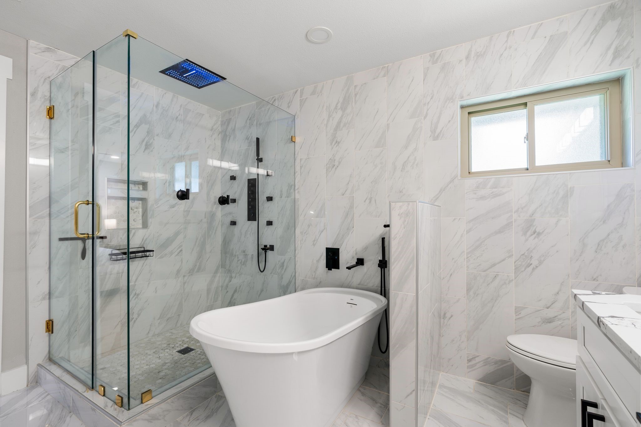 4423 Apollo Street Houston, TX 77018 - Photo 15 of 34 A spa-inspired primary bath with a 9-head shower, 20-inch LED rain shower with speaker and a soaking tub.