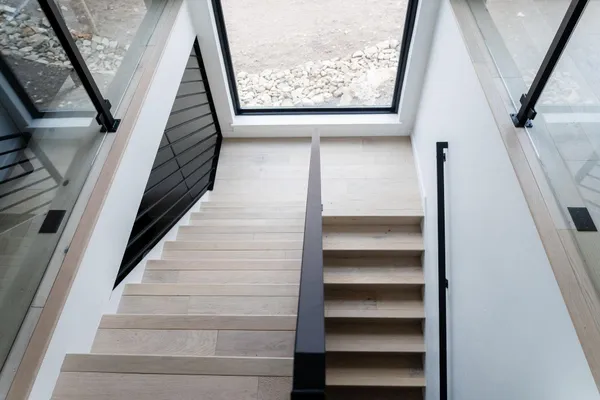 a view of staircase with wooden floor and white walls