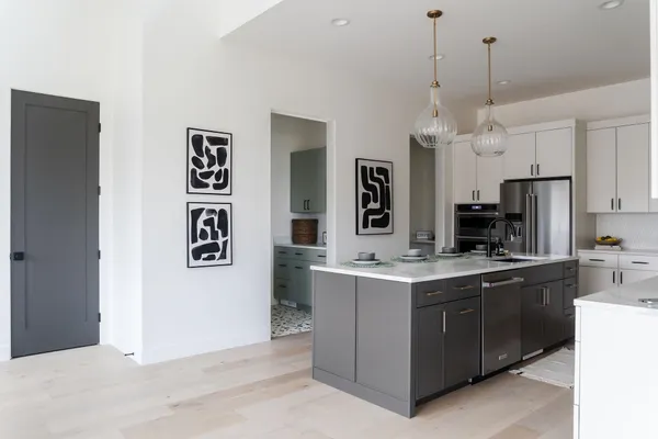 a kitchen with kitchen island a stove a sink a refrigerator and chairs