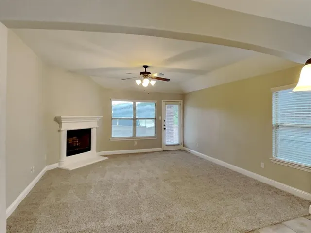 a view of an empty room with window and fire place