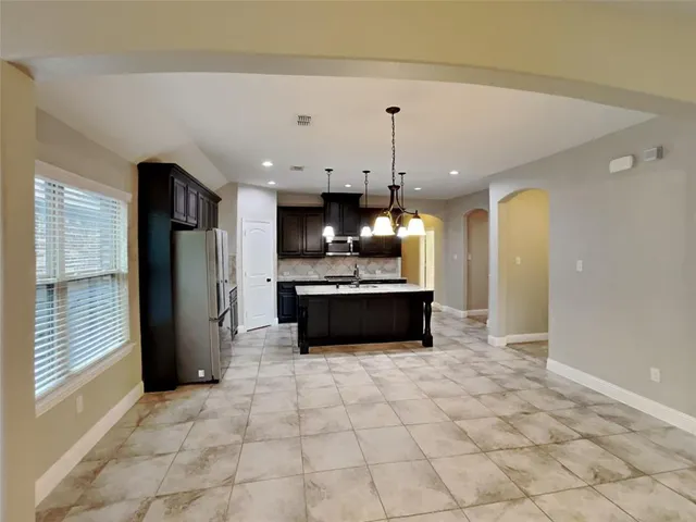 a large kitchen with a stove a refrigerator and a sink
