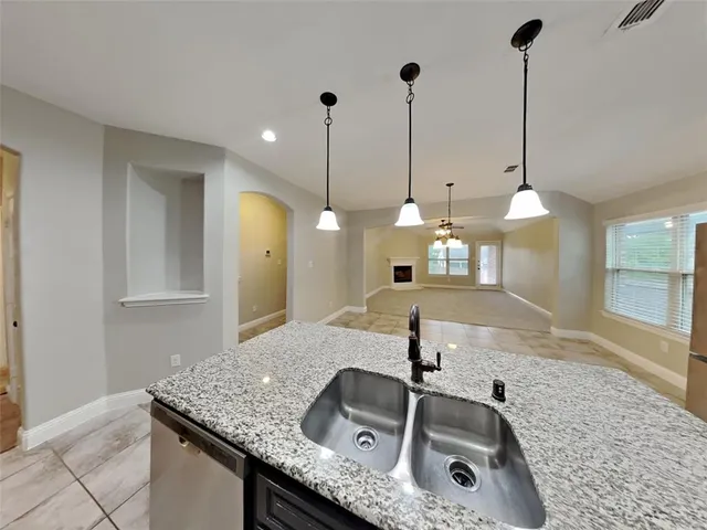 a kitchen with a sink a faucet a chandelier and kitchen view