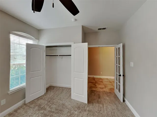 an empty room with windows and closet