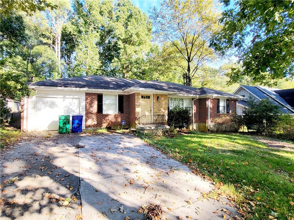 a view of a house with a yard and large tree