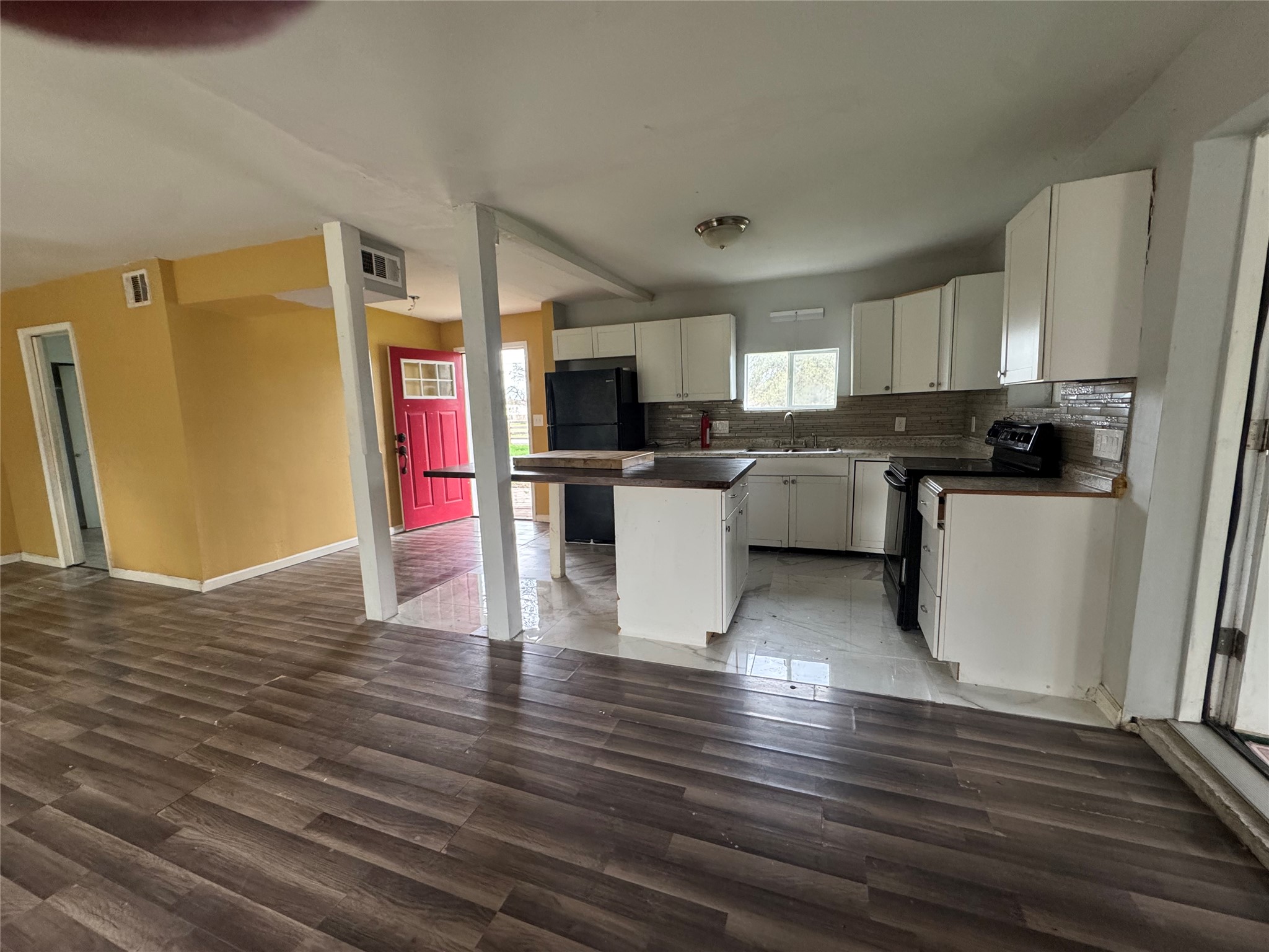 6304 Hudson Bend Road Austin, TX 78734 - Photo 10 of 10 Kitchen with a center island, dark countertops, black appliances, backsplash, and open floor plan