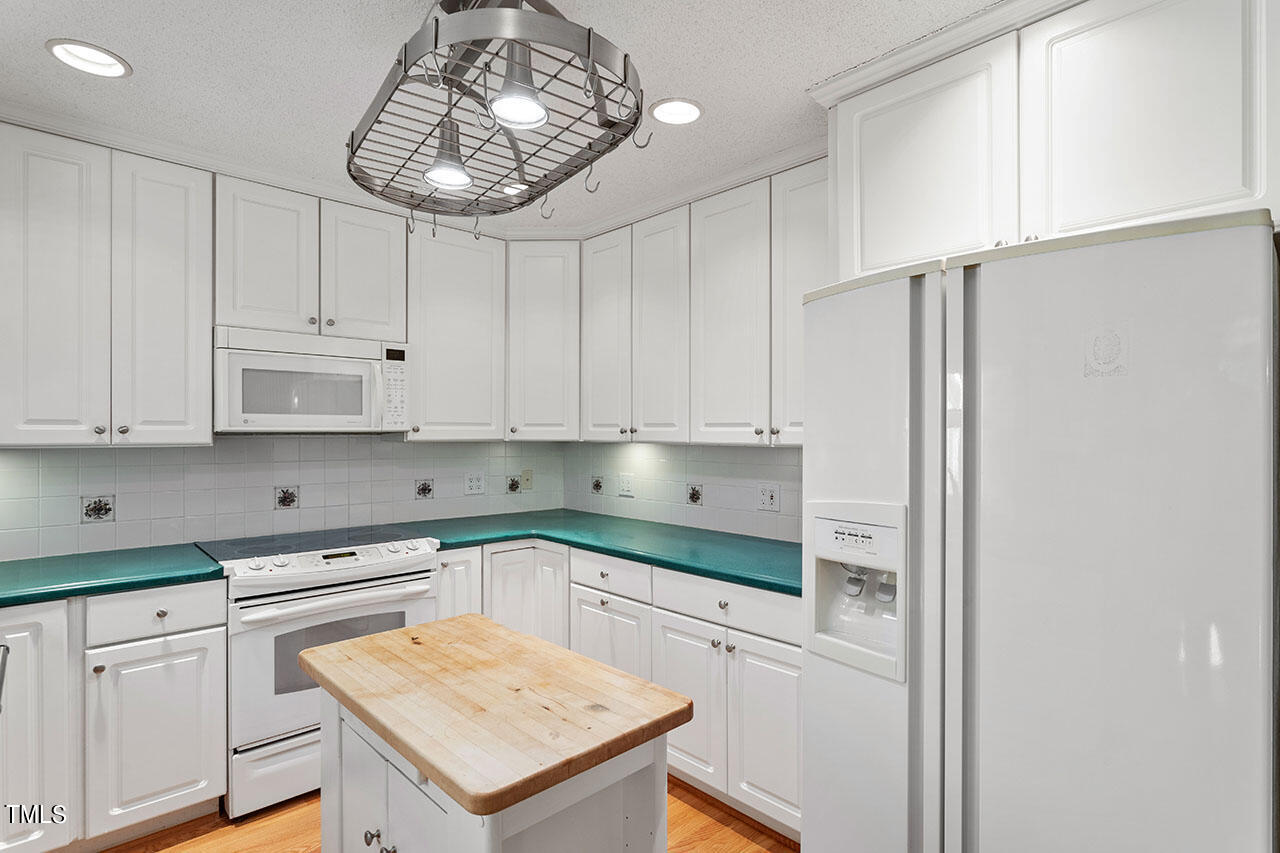 3124 Coachman's Way Durham, NC 27705 - Photo 14 of 30 a kitchen with white cabinets and refrigerator
