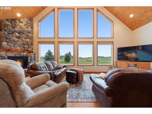 a living room with furniture a floor to ceiling window and a flat screen tv