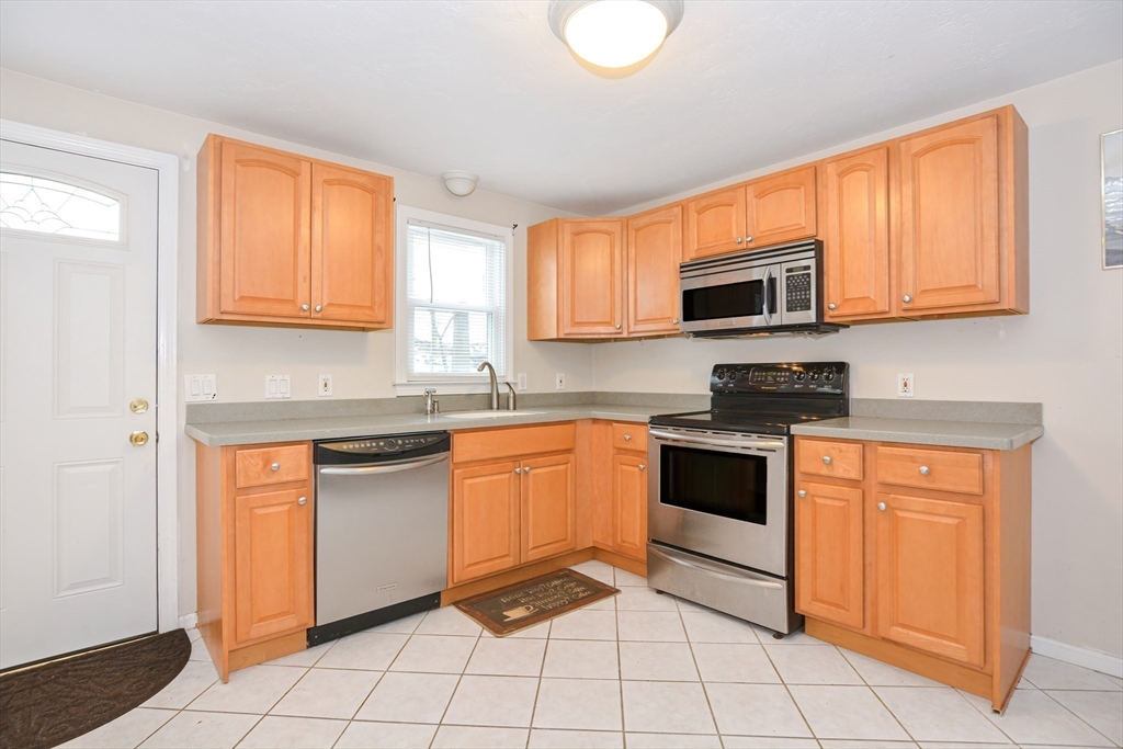 2 Hartness Road, Unit A Sutton, MA 01590 - Photo 10 of 37 a kitchen with granite countertop a stove top oven microwave and cabinets