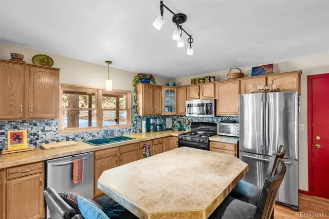 a kitchen with a table chairs refrigerator and cabinets