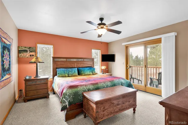 a bedroom with a large bed and a chandelier fan