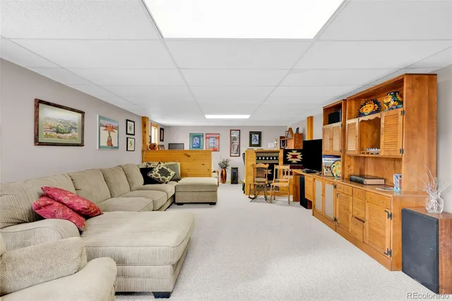 a living room with furniture kitchen view and a large window