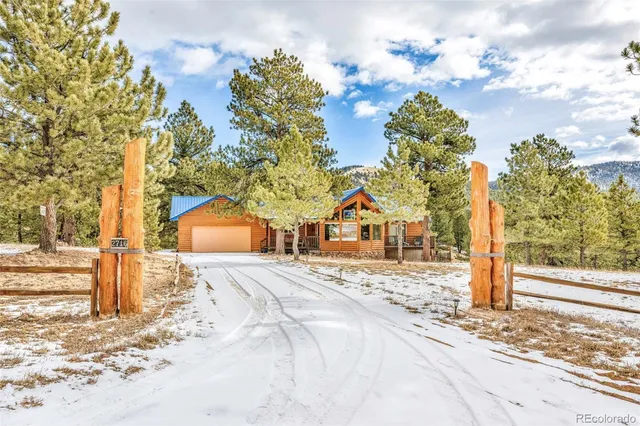 a front view of a house with a yard covered with snow