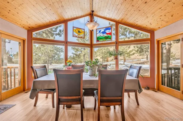 a view of a dining room with furniture large windows and wooden floor