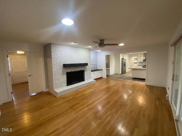 a view of an empty room and a kitchen