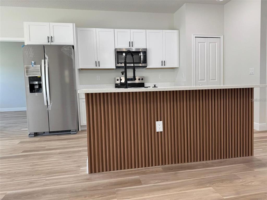 2336 Southwest 168th Loop Ocala, FL 34473 - Photo 11 of 40 a kitchen with stainless steel appliances granite countertop white cabinets and refrigerator