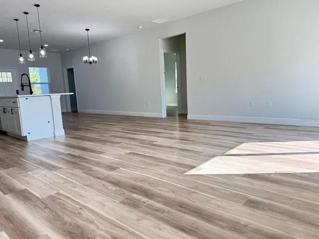 a view of a room with a ceiling fan and wooden floor