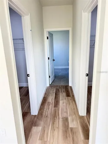 a view of a hallway with wooden floor and staircase