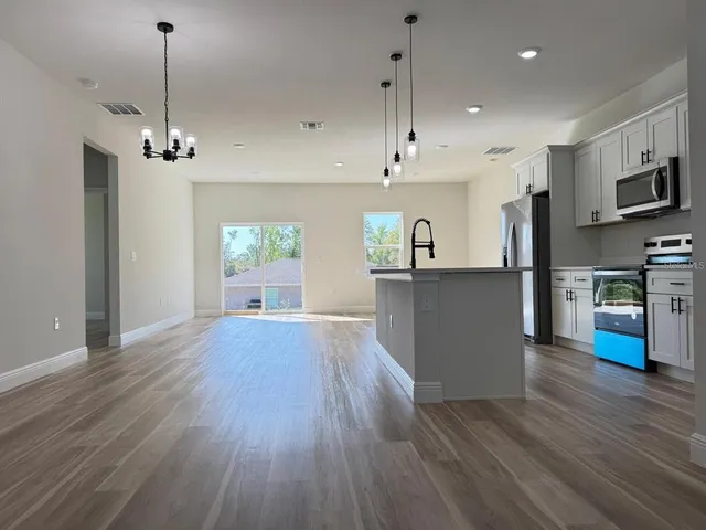 a view of a kitchen with wooden floor and a window