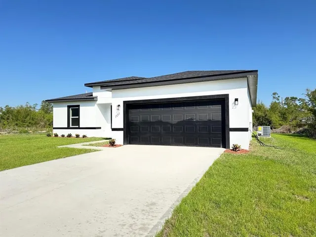 a front view of a house with a yard and garage