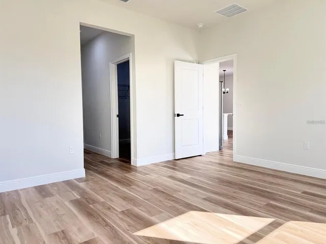 a view of an empty room with closet and a window