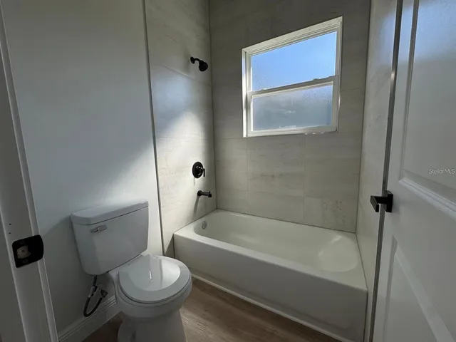 a white toilet sitting next to a bath tub