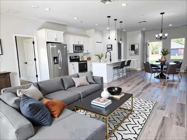 a living room with furniture kitchen and a dining table