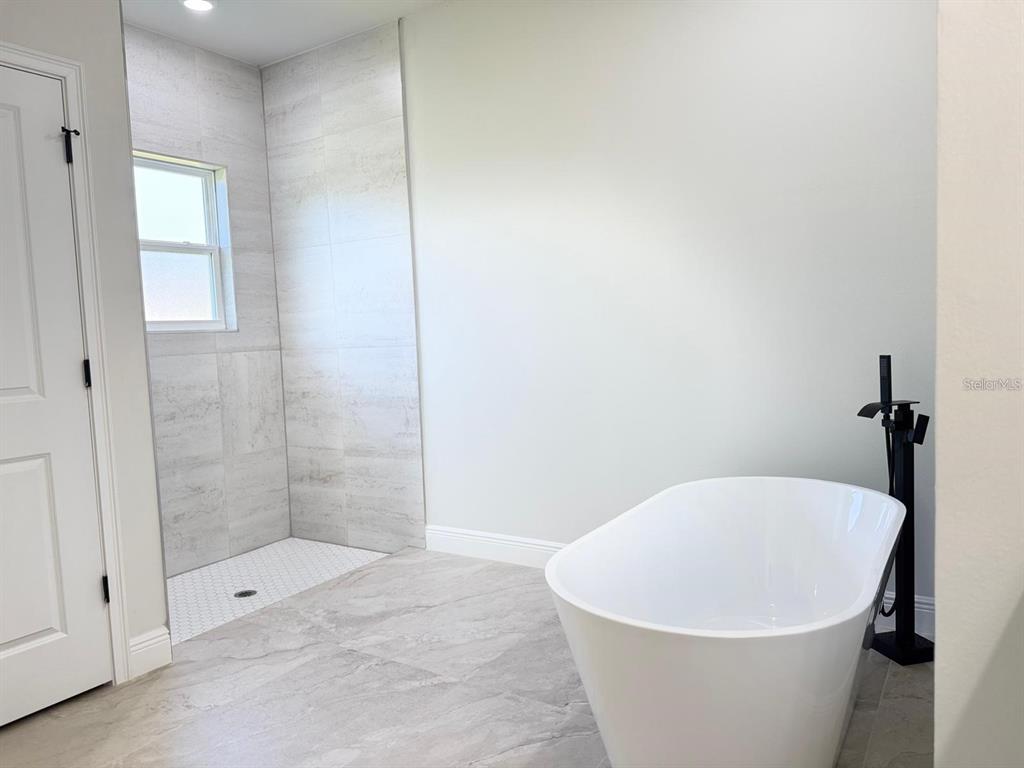 2336 Southwest 168th Loop Ocala, FL 34473 - Photo 6 of 40 a white bath tub sitting in a bathroom