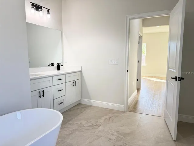 a bathroom with a tub sink and mirror