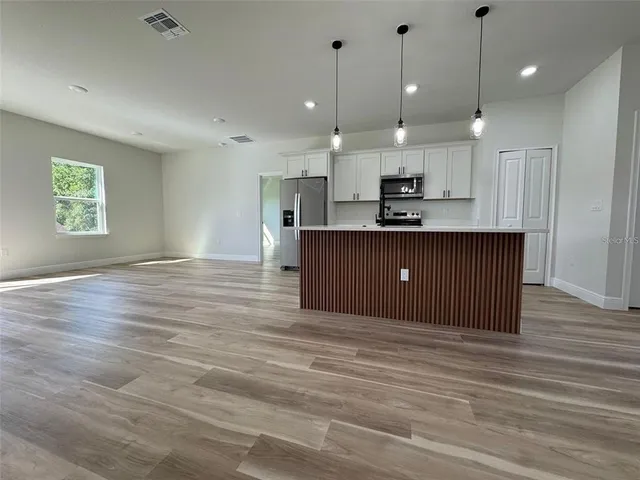 a view of kitchen and kitchen with stainless steel appliances granite countertop cabinets