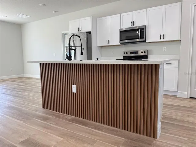 a view of kitchen with stainless steel appliances granite countertop white cabinets a sink and dishwasher