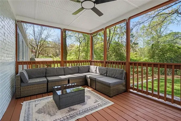 a living room with furniture floor to ceiling window and wooden floor